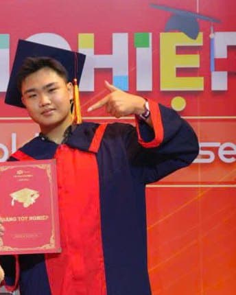 Trần Chí Thành mặc áo tốt nghiệp, cầm bằng tốt nghiệp tại lễ tốt nghiệp FPT Polytechnic